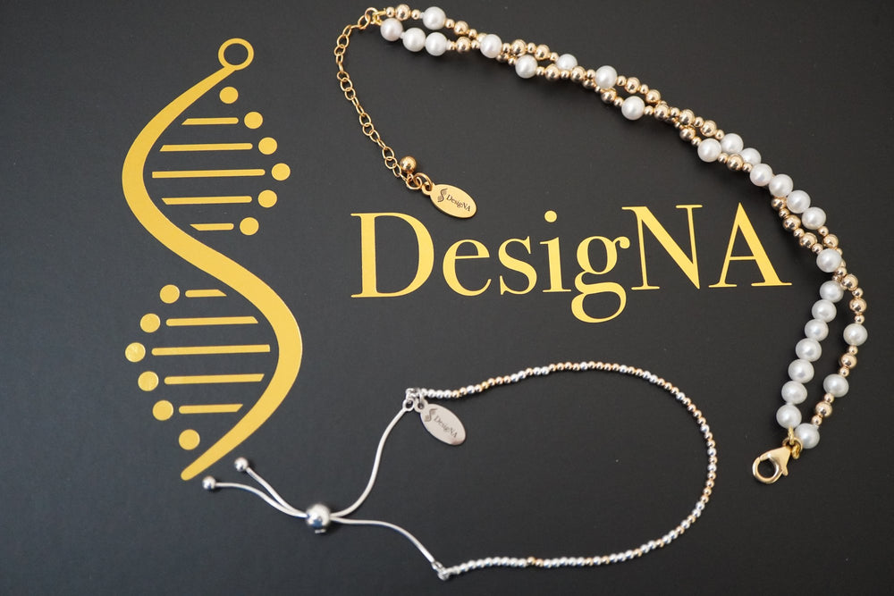 Three DNA Profile Bracelets laid on the gold DesigNA box lid