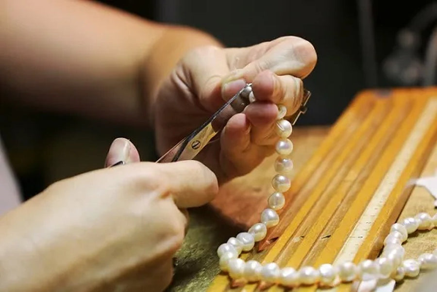 Handmade jewellery Birmingham Jewellery Quarter: a DesigNA strand strung by hand beside its certificate