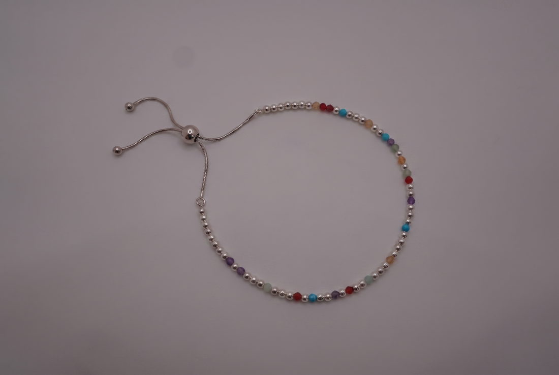 DNA bracelet gift laid flat in a gift box, showing the coloured stone markers