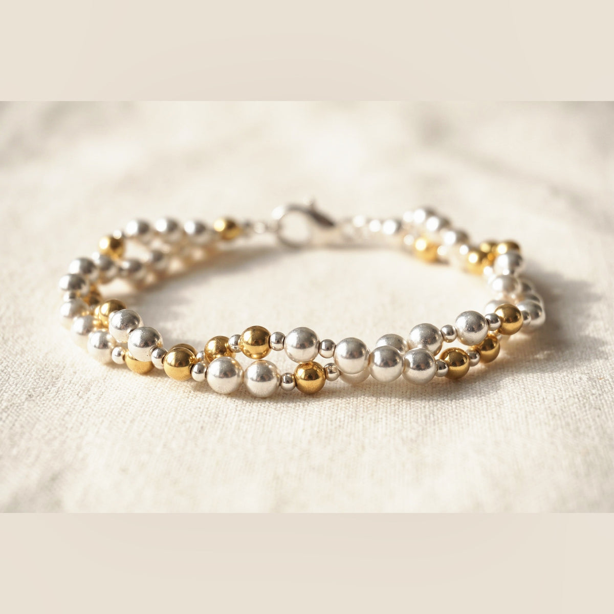 Twisted Silver and Gold DNA Profile Bracelet, flat lay