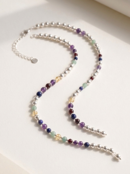 Silver Sphere DNA Profile Necklace laid in an open curve, showing the full run of markers, the clasp and the extension chain