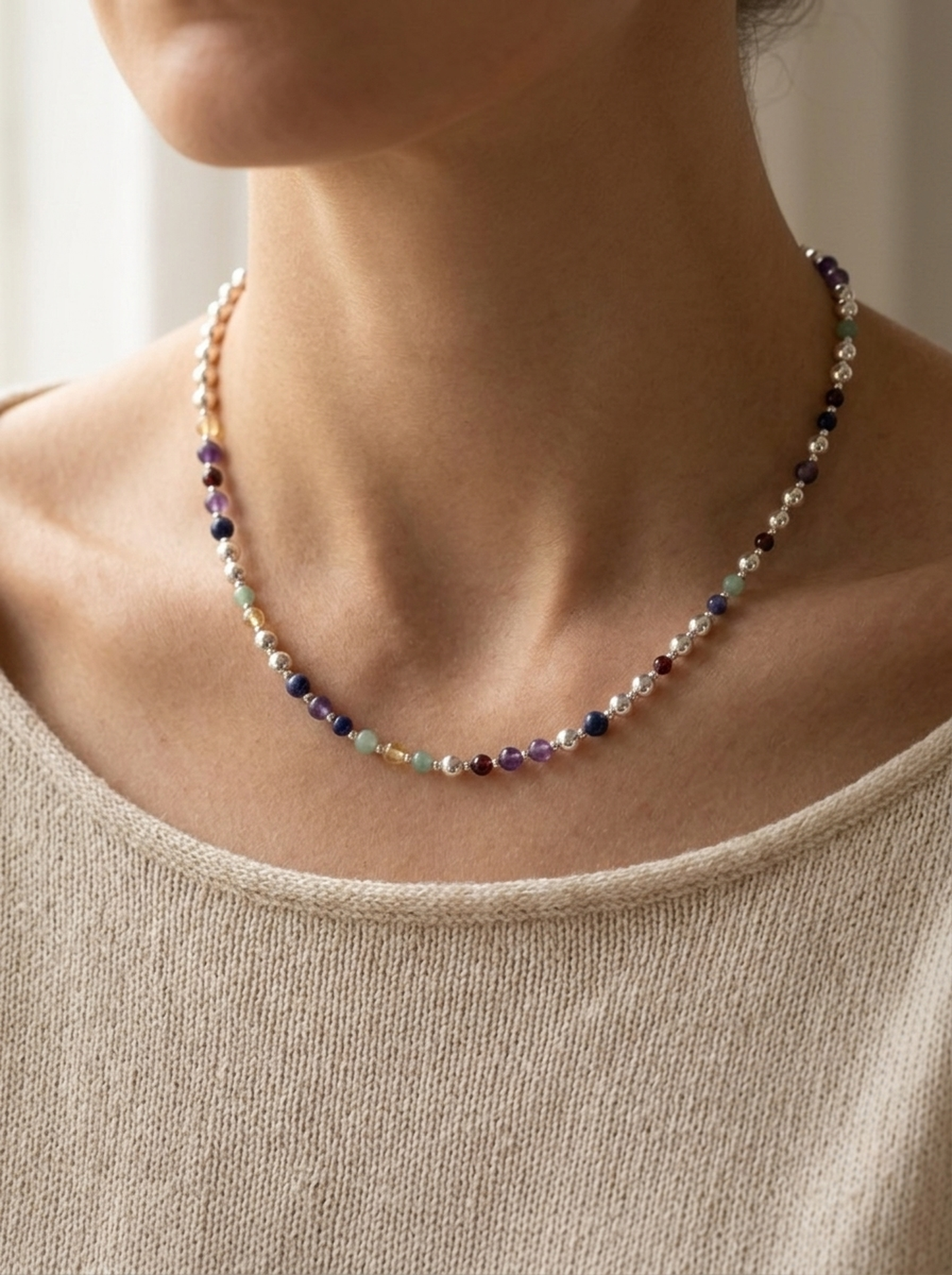 Silver Sphere DNA Profile Necklace worn at the base of the neck, sterling silver spheres with gemstone markers in the order the DNA places them