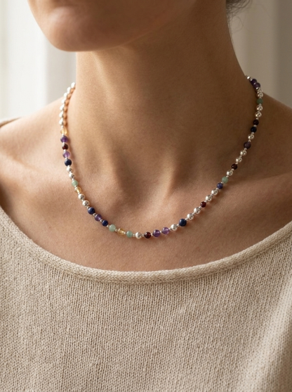 Silver Sphere DNA Profile Necklace worn at the base of the neck, sterling silver spheres with gemstone markers in the order the DNA places them