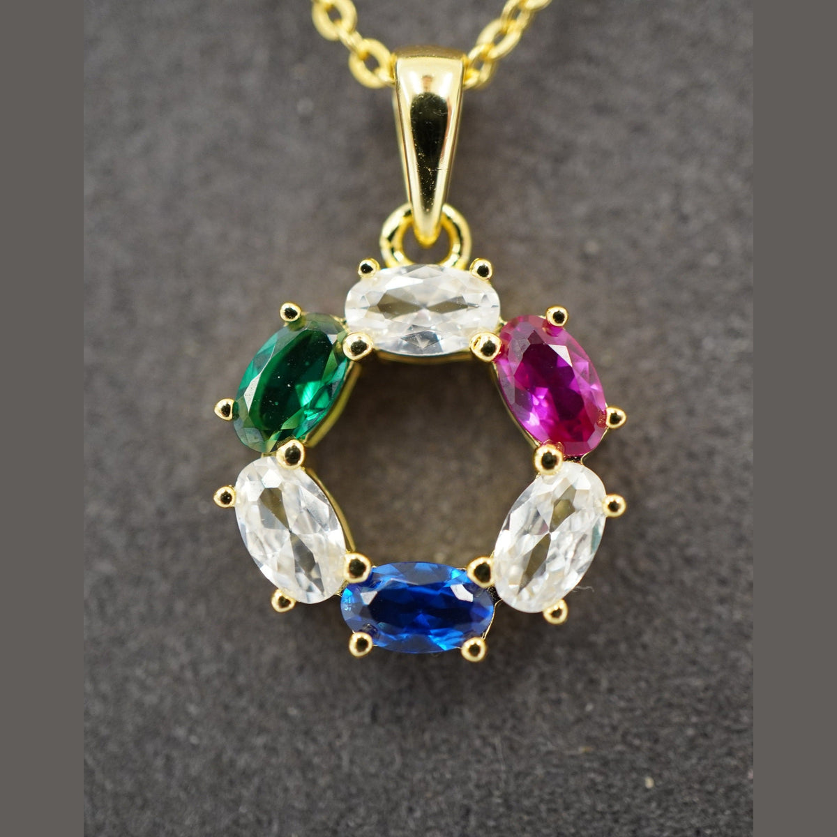 DNA Representation Pendant, a circular gold plated setting with six oval zircon stones on a fine cable chain
