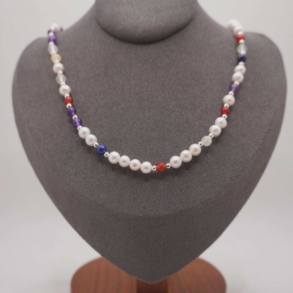 Pearl DNA Profile Necklace on the display bust, light moving across the pearls