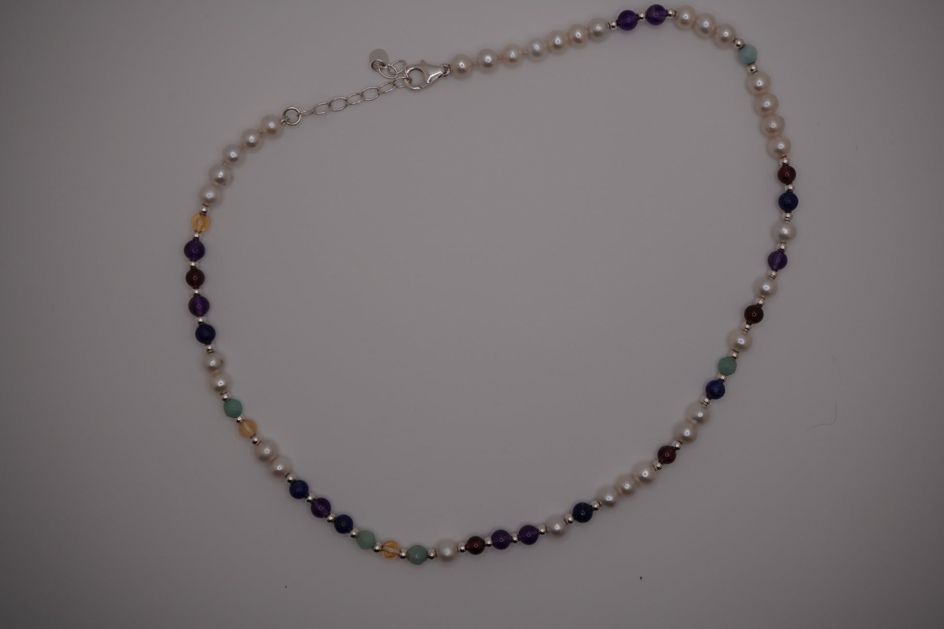 Silver DNA Profile Necklace laid flat on a soft grey background