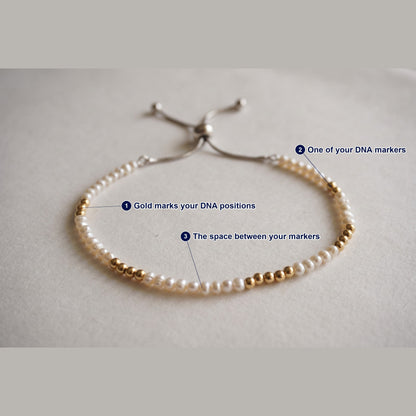 Spider Pearl and Gold DNA Profile Bracelet photographed flat, with each part of the piece labelled.