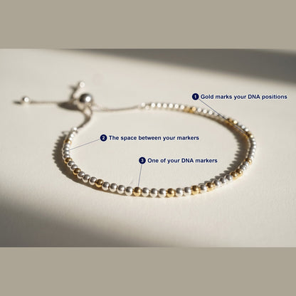 Spider Silver and Gold DNA Profile Bracelet photographed flat, with each part of the piece labelled.