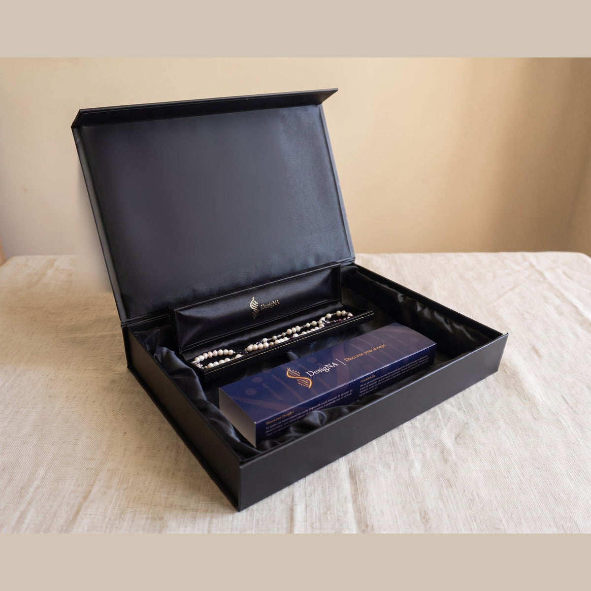 Your second delivery: the finished piece presented in the open DesigNA box with the navy sleeve