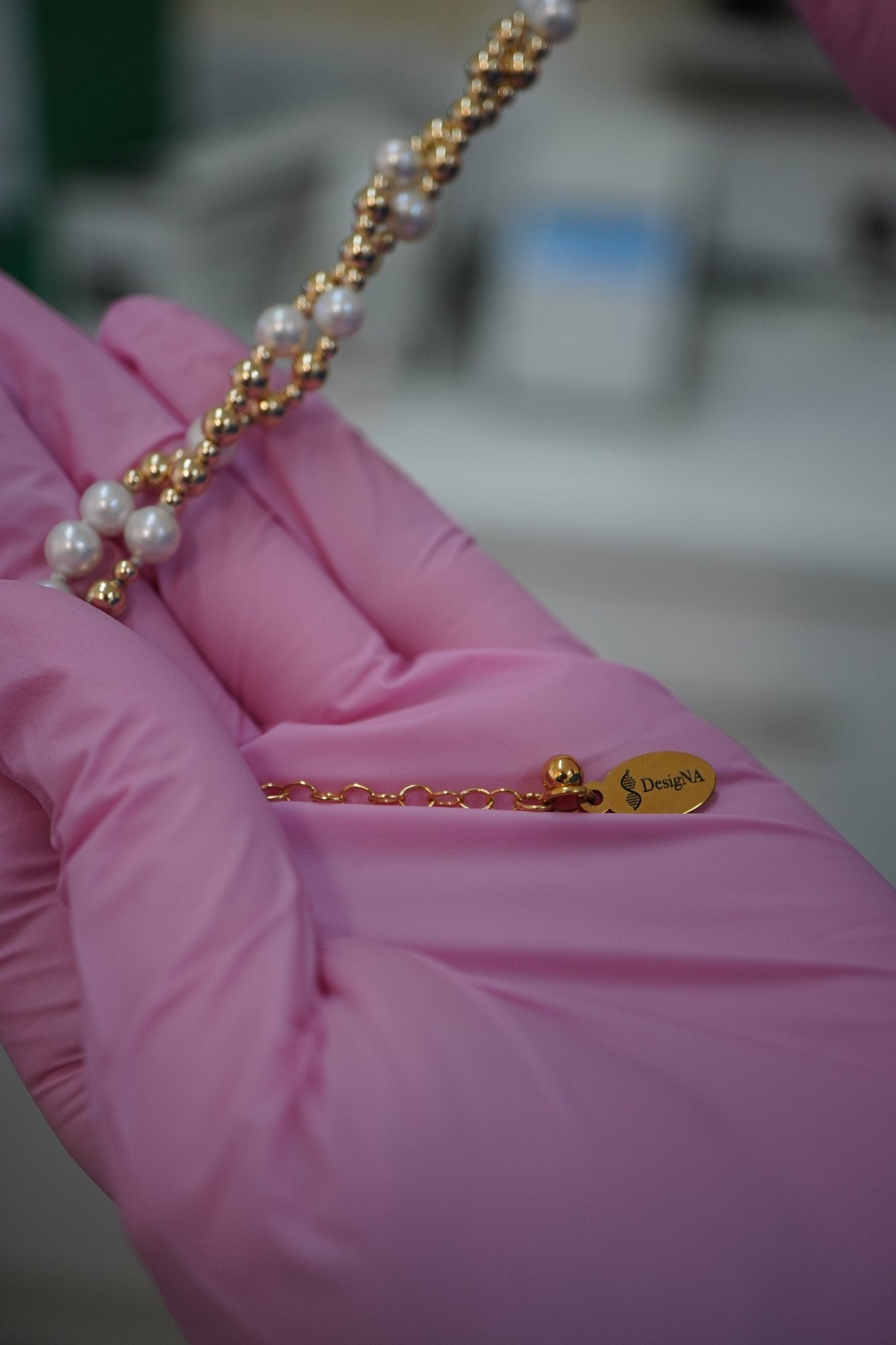 Twisted Pearl and Gold DNA Profile Bracelet draped over a palm