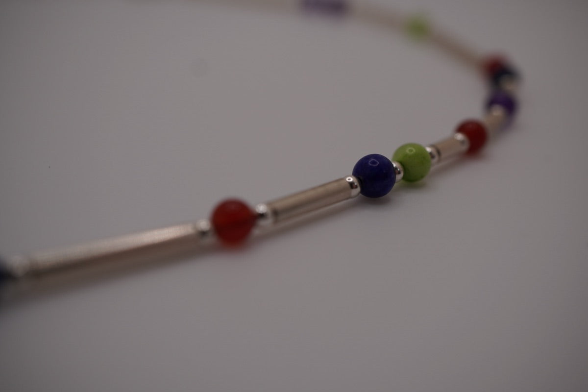 Macro of silver batons and stone markers on a DNA Profile Necklace